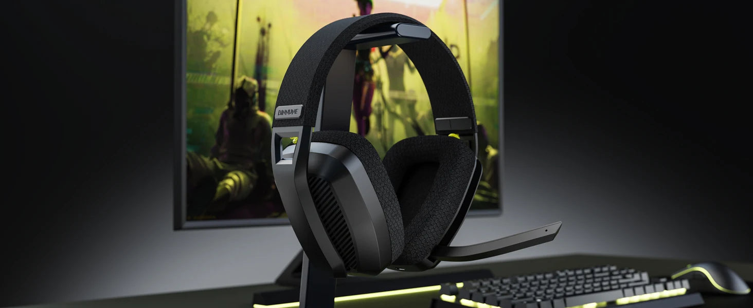 Gaming headset on a stand with a computer monitor and keyboard in the background